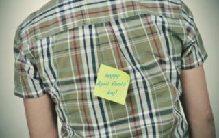 man with a sticky note with the text happy april fools day