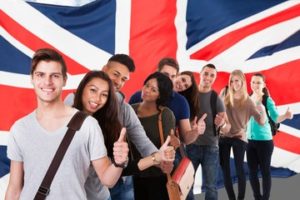 student posing with the Union jack flag with a thumbs up