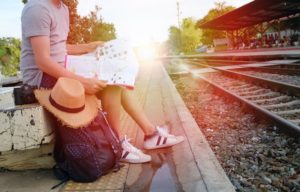 Student looking at map and waiting for a train Student looking at map and waiting for a train